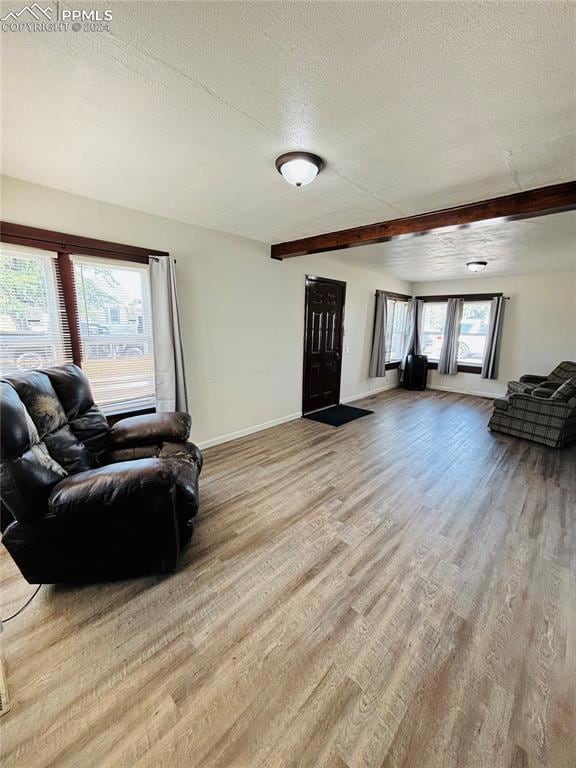 Living room with a textured ceiling, light hardwoo