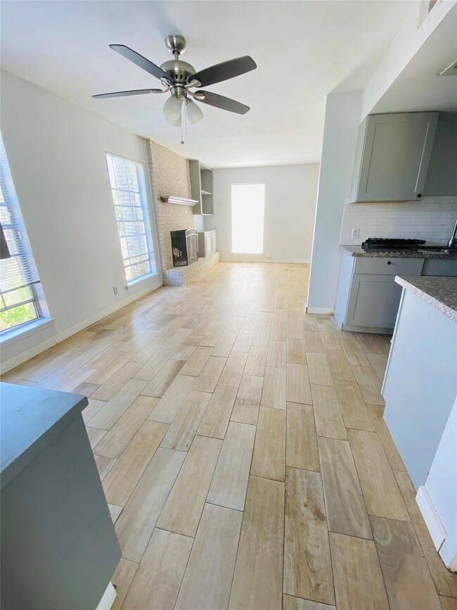 Unfurnished living room featuring baseboards, woo