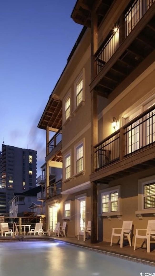 View of building exterior featuring an outdoor pool