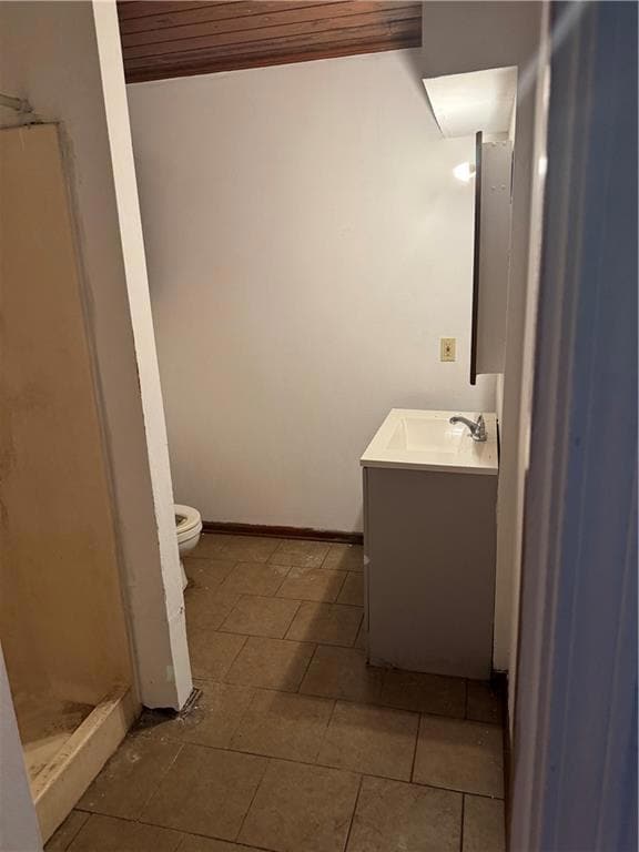 Bathroom with toilet, vanity, wood ceiling, a shower stall, and tile patterned flooring