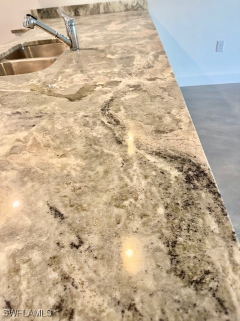 Kitchen view of a sink, light stone countertops, a