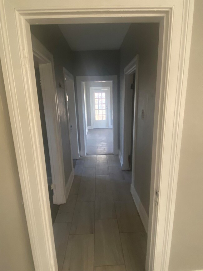 Hall featuring dark tile flooring