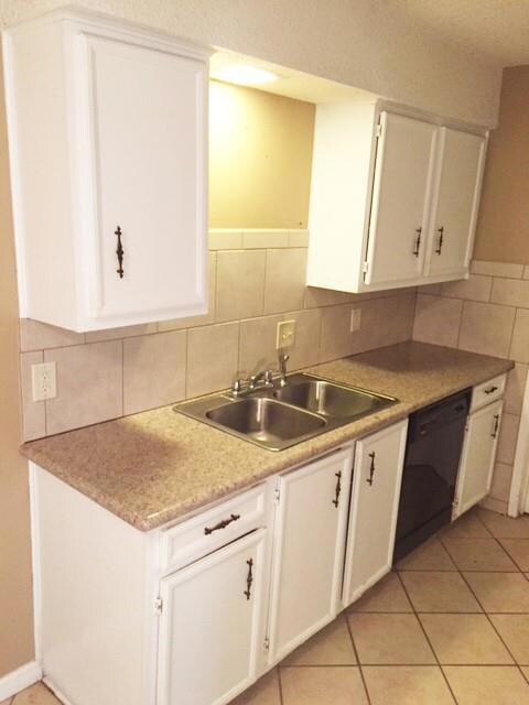 Kitchen with white cabinets, light tile patterned