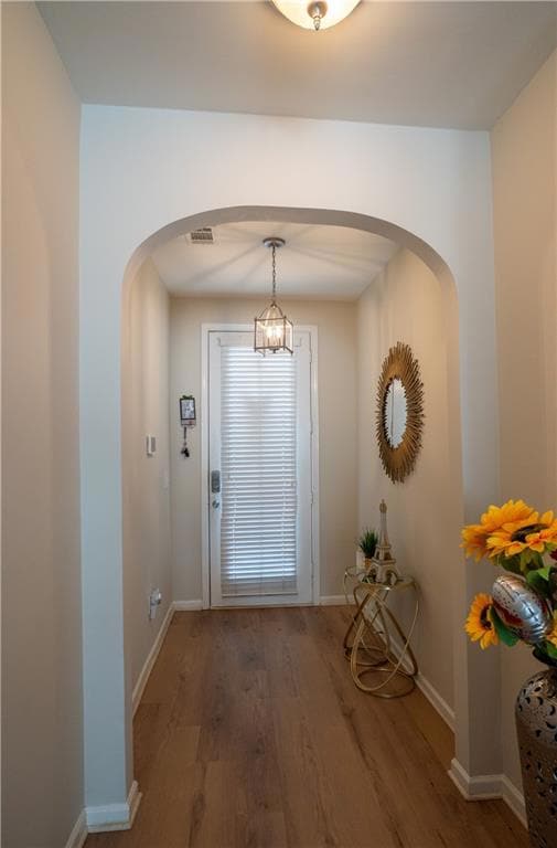 Entryway with arched walkways, wood finished floor
