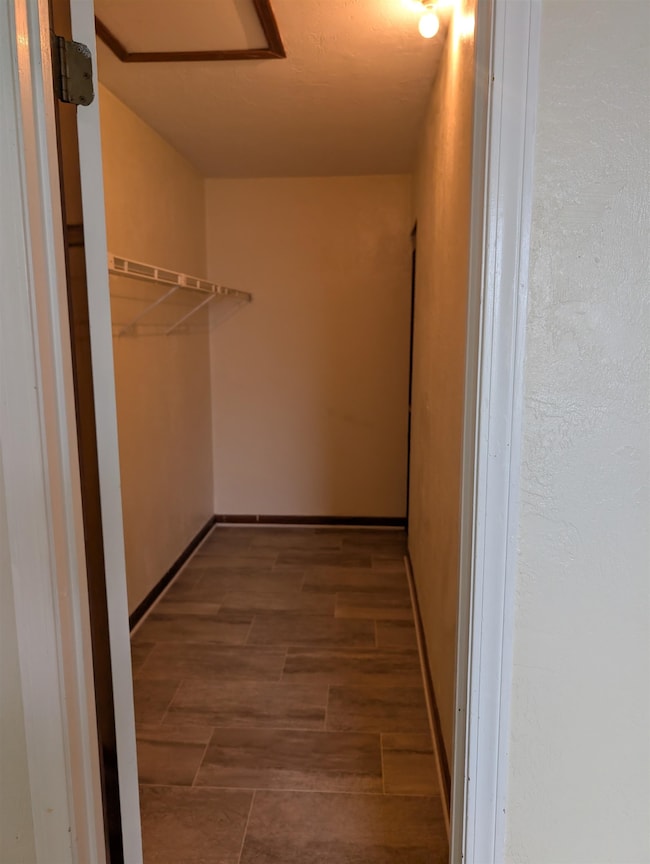Spacious closet featuring elevator and dark wood finished floors