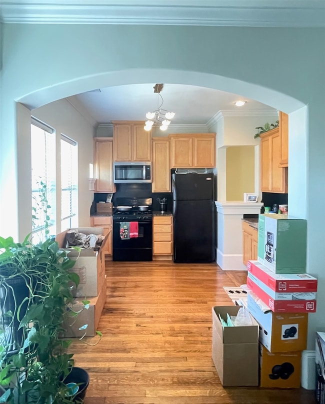 View from living room through the arched doorway into the kitchen. Plenty of room below the windows on the left for a dining table.