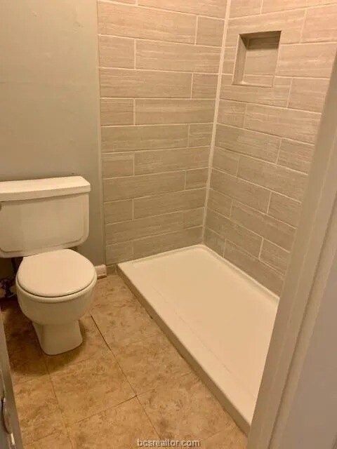 Bathroom with a tile shower, tile patterned floors