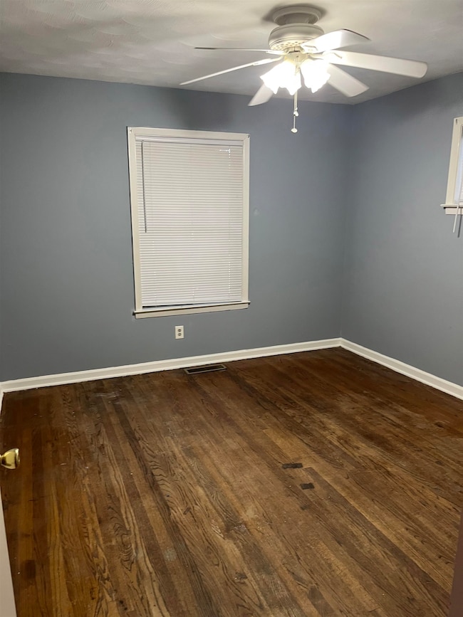 Spare room with a ceiling fan and dark wood-style flooring