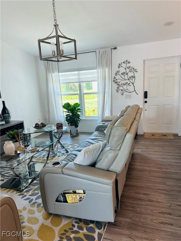 Living area with wood finished floors and a chande