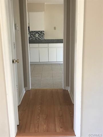 Hardwood Floor between the sunken living room and the ceramic tile kitchen and hall half bath