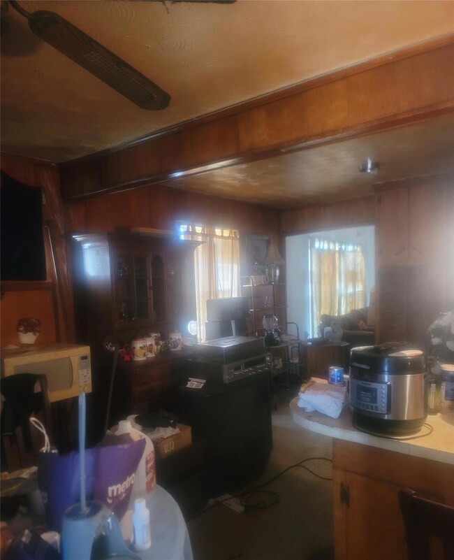 Kitchen with wooden walls and ceiling fan