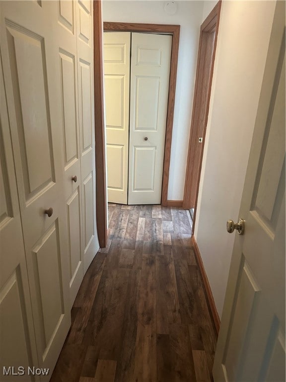 Corridor with dark wood-style floors and baseboards