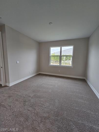 Empty room with carpet and baseboards