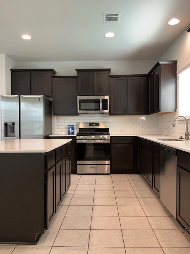 Kitchen with stainless steel appliances, light co