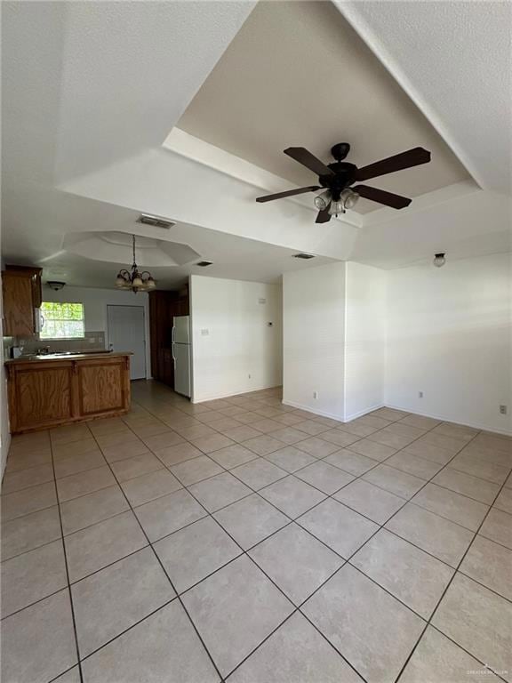 Unfurnished living room with a tray ceiling, light tile patterned floors, a textured ceiling, and ceiling fan