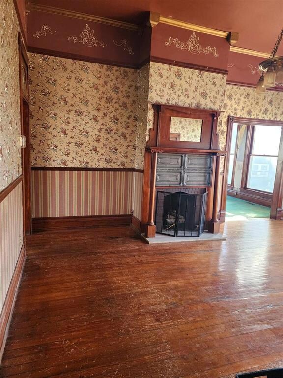 Unfurnished living room with ornamental molding an