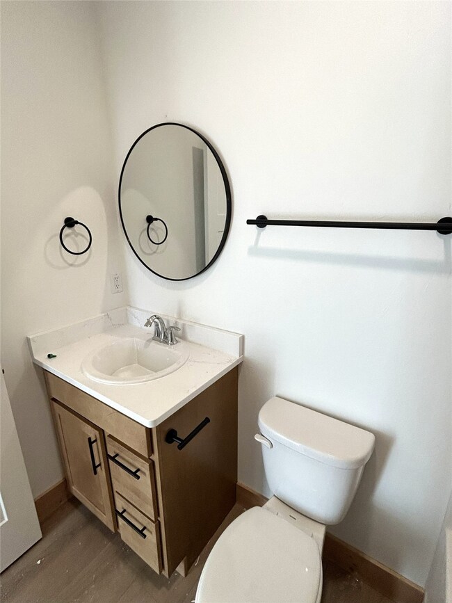 Half bath featuring vanity and wood finished floors