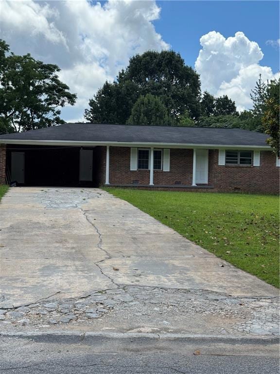 Ranch-style house with a carport, a front lawn, concrete driveway, and brick siding