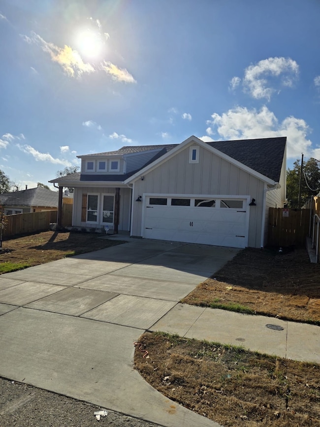 View of front of property featuring driveway, board and batten siding, an attached garage, and a shingled roof