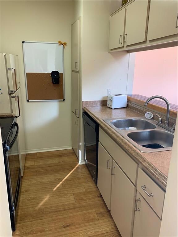 Kitchen featuring black appliances and light wood