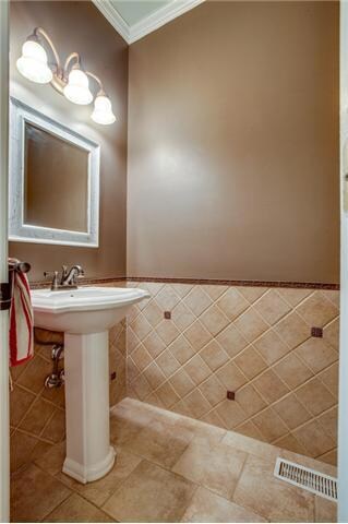 This renovated half bath has tiled floor, new hardware, new fixture, sink,  and is located on the main level.