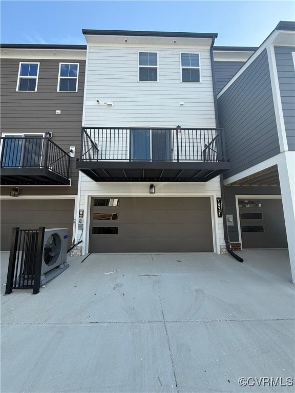 Rear view of house with a garage, driveway, and a