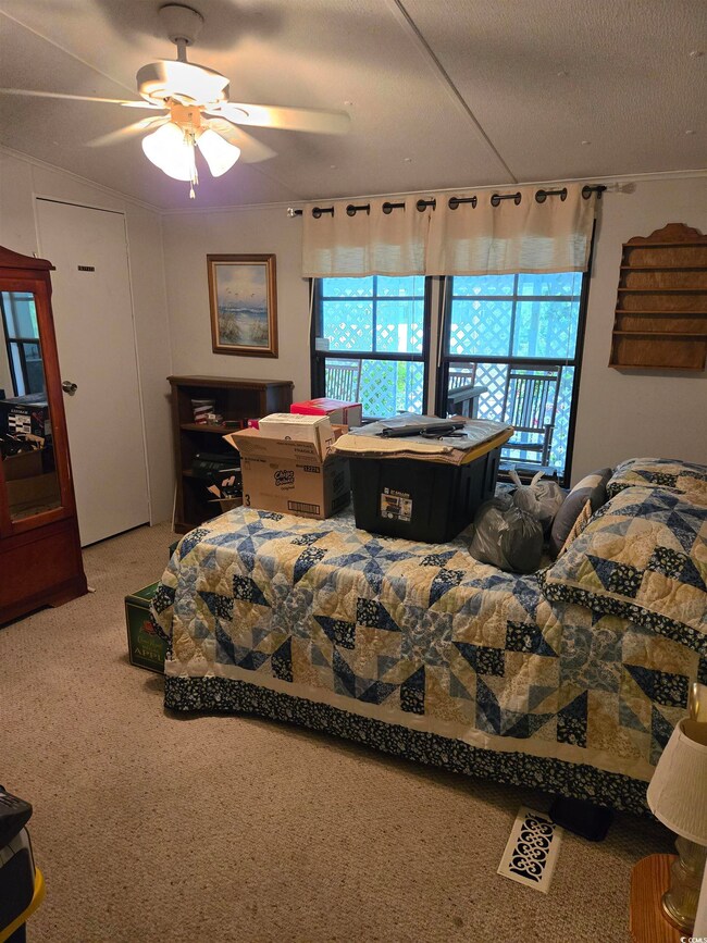 Carpeted bedroom featuring ceiling fan