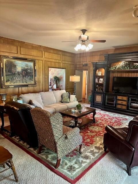 Living room with wooden walls and ceiling fan