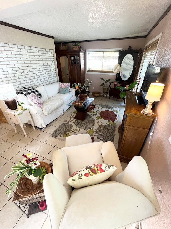 Living room featuring tile patterned flooring, a textured ceiling, and crown molding