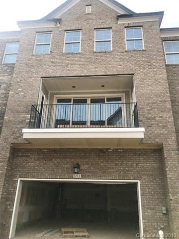 Back of the home with large deck and 2 car garage 