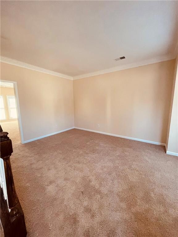 Carpeted spare room featuring baseboards, visible 