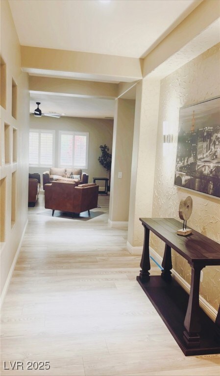 Hall with a textured wall, wood finished floors, a