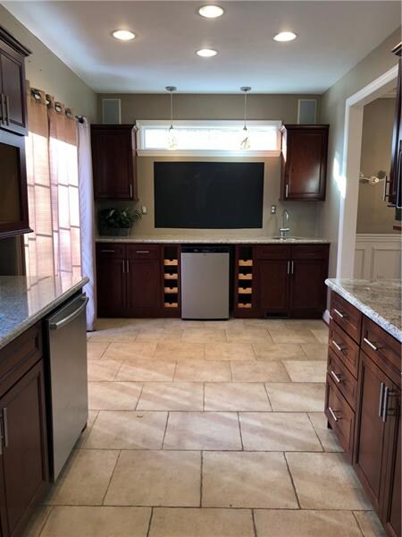 Wet bar featuring a wine fridge, wine racks, plent