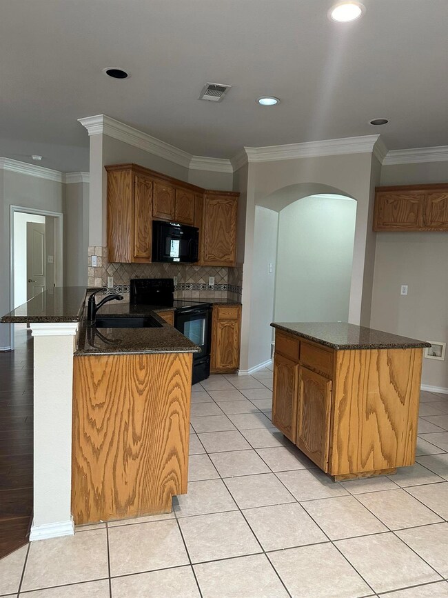 Kitchen with light tile patterned flooring, black 