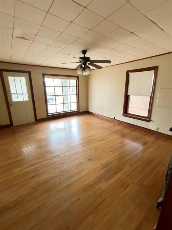 Unfurnished room with plenty of natural light, a ceiling fan, and light wood-style floors