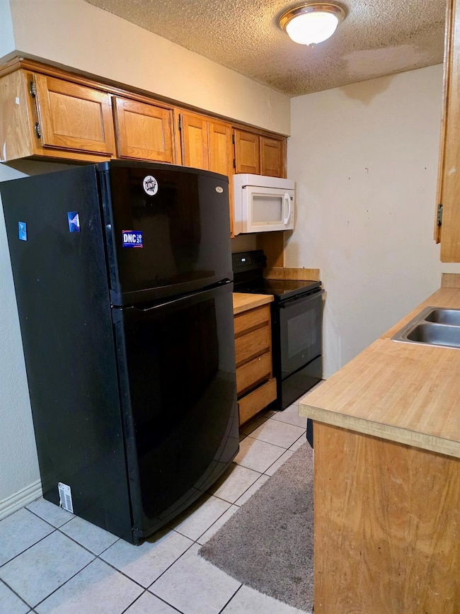 Kitchen featuring light tile patterned floors, bro