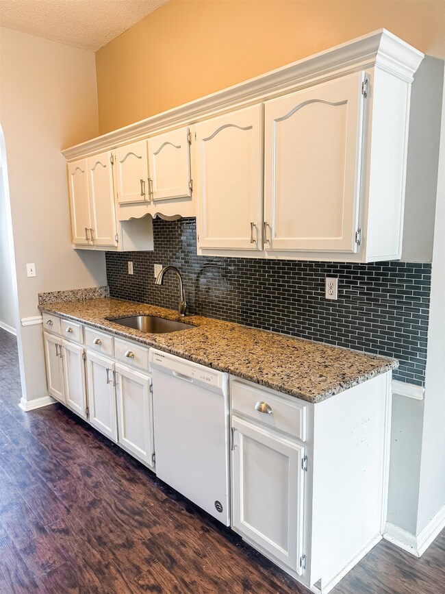 Kitchen with tasteful backsplash, dishwasher, dark