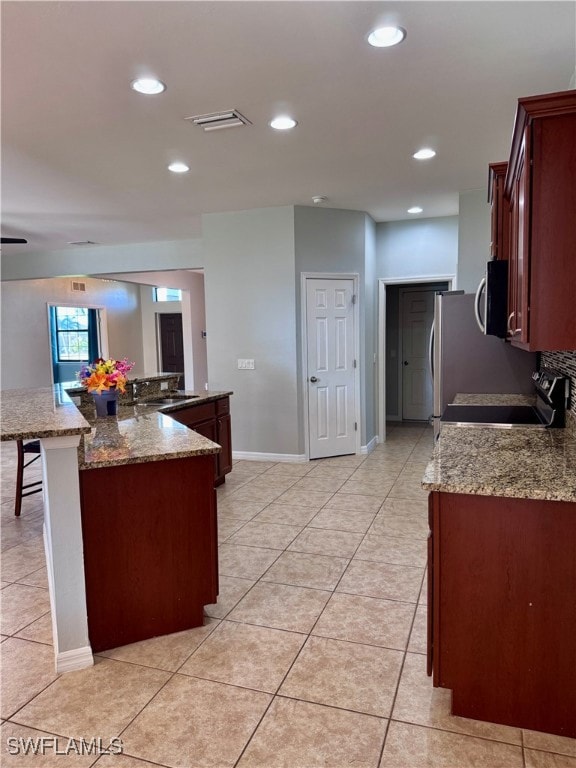 Kitchen with a kitchen bar, light tile patterned f