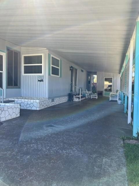 Carport area with view of entrance to Florida Room, Living Area and utility/Laundry Room