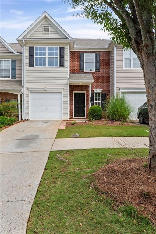 View of front facade featuring brick siding, an attached garage, concrete driveway, and a front lawn