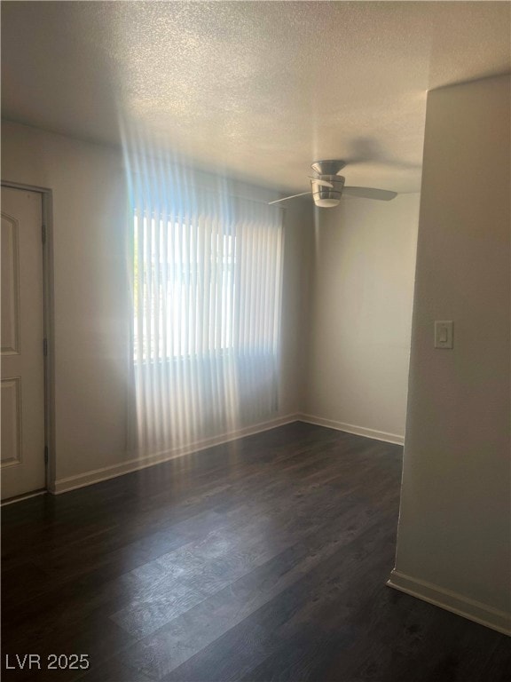 Empty room with dark wood-style flooring, a ceilin