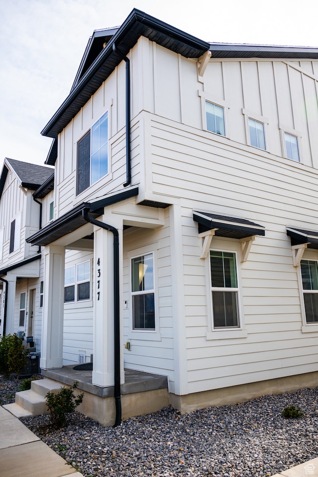 View of side of property featuring board and batten siding and covered porch