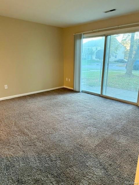 Carpeted empty room featuring baseboards