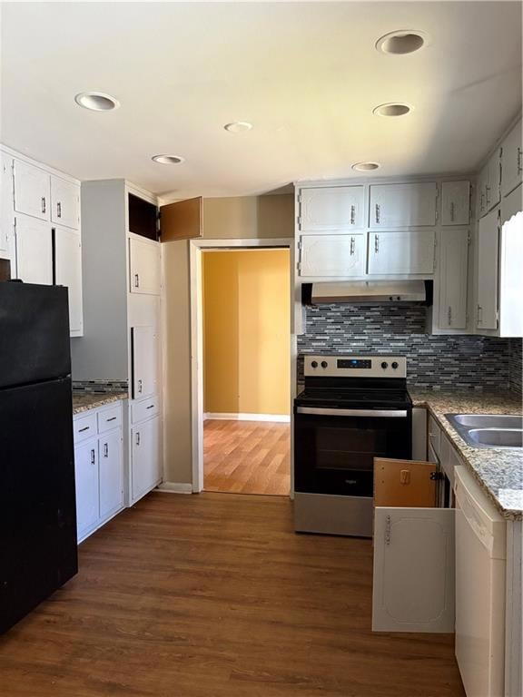 Kitchen with stove, fridge, tasteful backsplash, dark wood finished floors, and light stone countertops