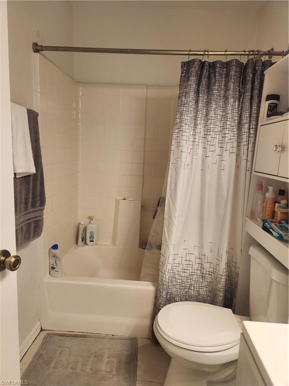 Bathroom with tile flooring, toilet, and shower / 
