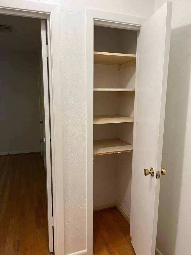 This photo shows a small closet with several shelv