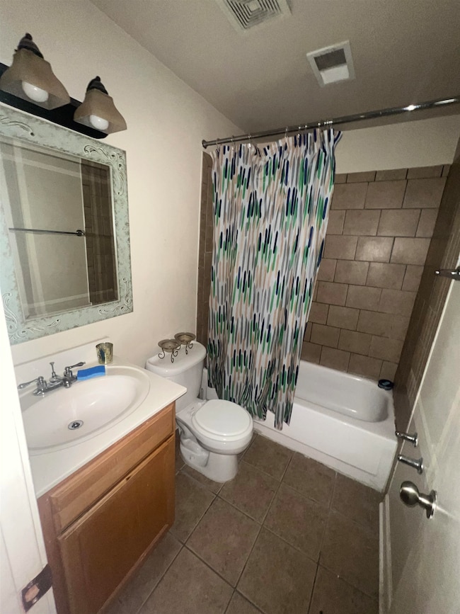 Full bath with vanity, shower / tub combo with curtain, and tile patterned flooring