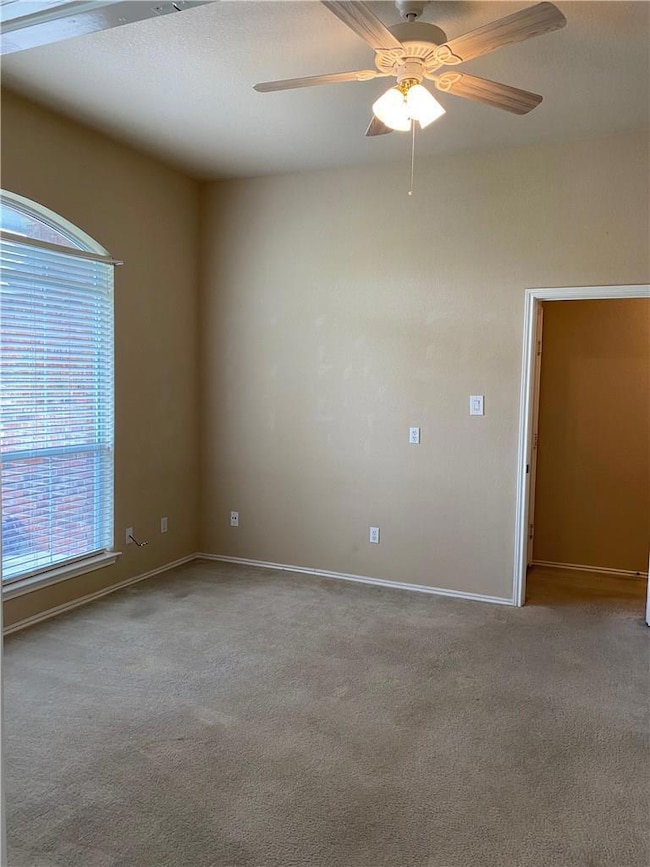 Unfurnished room featuring a ceiling fan and carpet that has been replaced with luxury vinyl plank flooring.