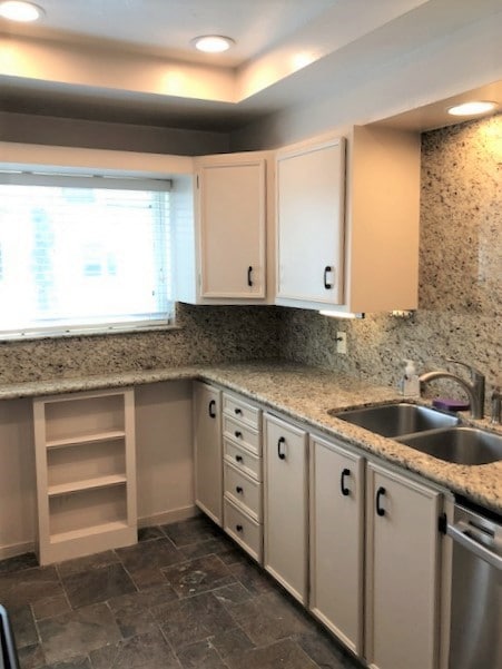 This well equipped kitchen has granite counters, recessed lighting and slate floors.