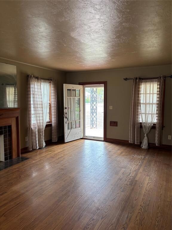 Unfurnished living room featuring baseboards, a te